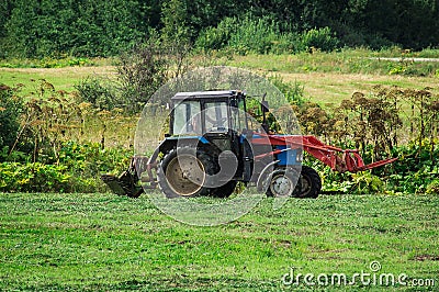 The tractor on the hay in Russia. Editorial Stock Photo