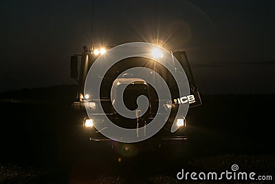 Tractor with headlights on at night time Editorial Stock Photo