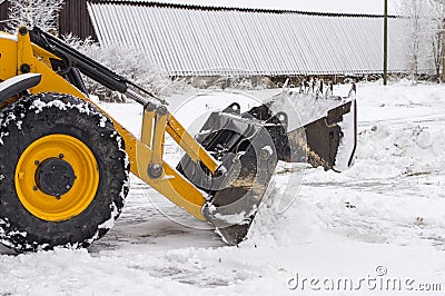 Tractor loader cleans snow after a snowfall Stock Photo