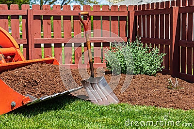 Tractor loader with wood chips or mulch and flowerbed Stock Photo