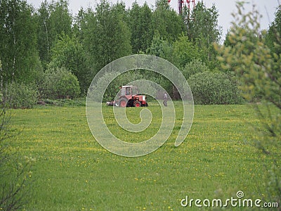 Senior farmer on the field examines the tractor Stock Photo