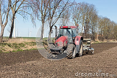 Tractor plough at bare Dutch field in early springtime Stock Photo