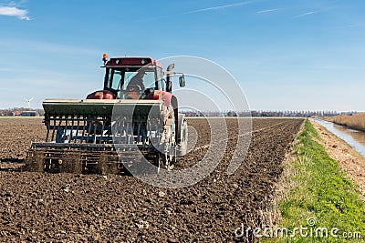 Tractor plough at bare Dutch field in early springtime Stock Photo