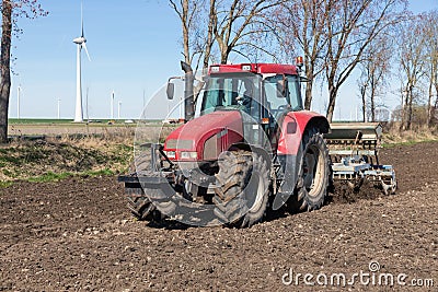 Tractor plough at bare Dutch field in early springtime Stock Photo