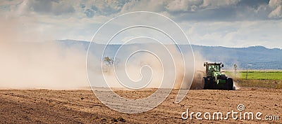 Tractor plowing dry farm land Stock Photo