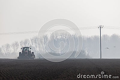 Tractor plowing the land in the morning Editorial Stock Photo