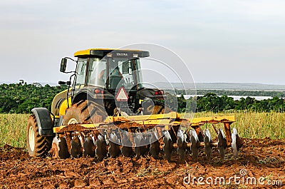 Tractor plowing and preparing the soil. Editorial Stock Photo