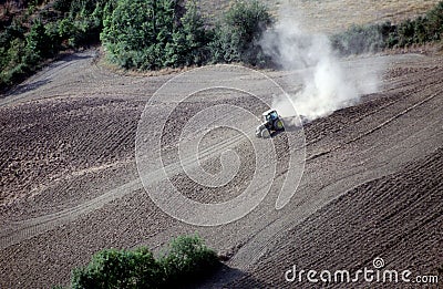 Tractor plowing a sloping field Stock Photo