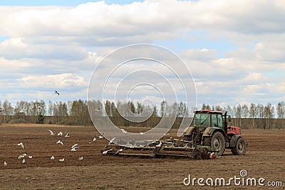 The tractor plows the field in the spring Editorial Stock Photo