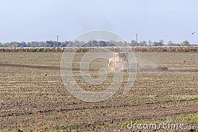 The tractor plows in the field Stock Photo