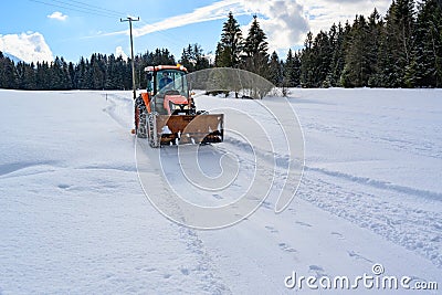 Tractor preparing slope on sunny winter day, Germany Editorial Stock Photo