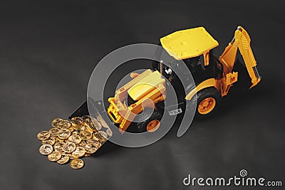 Tractor rake up money coins with a bucket Stock Photo