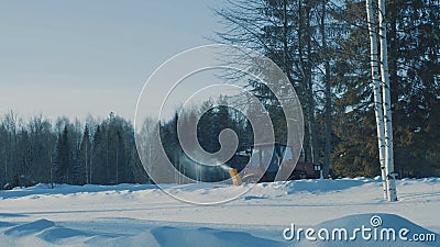 Tractor removing snow from the road in the forest Editorial Stock Photo