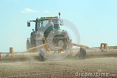 Tractor rolling field on a farm Editorial Stock Photo