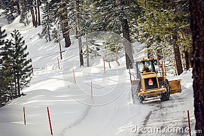 Tractor Snow Plows the Road Stock Photo