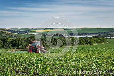 Tractor spraying corn field at sunset. Editorial Stock Photo