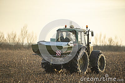 Tractor spreading artificial fertilizers Editorial Stock Photo