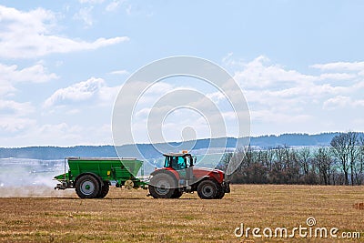 Tractor spreading fertilizer on grass field. Agricultural work Editorial Stock Photo