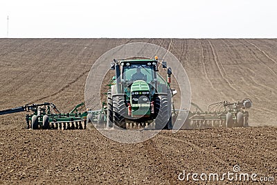 Tractor with trailed seeder on the field Editorial Stock Photo