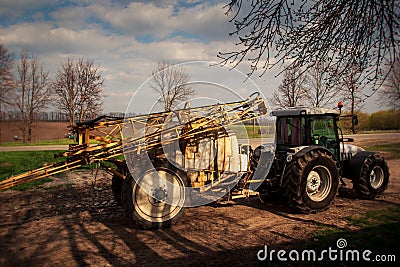 Tractor with trailer fertilizer-sprayer on country road Stock Photo