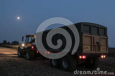 Tractor and trailer with headlights on at night time Editorial Stock Photo
