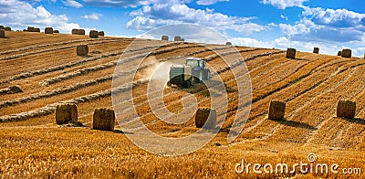 tractor uses a trailed bale machine to collect straw in the field and make round large bales. Agricultural work, hay collection Stock Photo