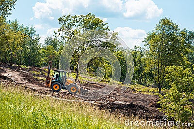 Tractor works on landscaping, tree branches and debris Stock Photo