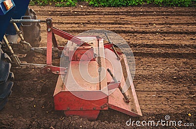 The tractor works the soil of the field by loosening and mixing it. Softening of the soil and destruction of the root system Stock Photo