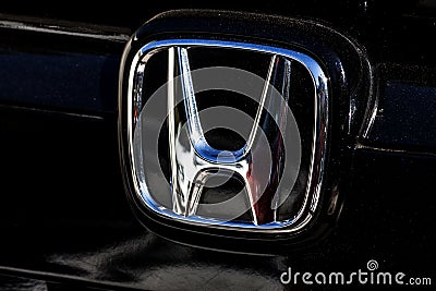 The trademark symbol of Honda in the frontside of a black car - photography Editorial Stock Photo