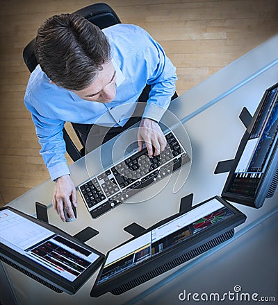 Trader Analyzing Data On Multiple Screens At Desk Stock Photo