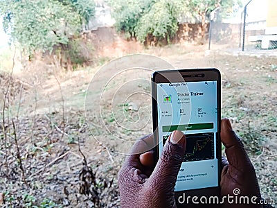 Trader trainer online share trading app for smart phone user displayed on digital screen Editorial Stock Photo