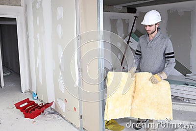 Tradesman installing insulation Stock Photo