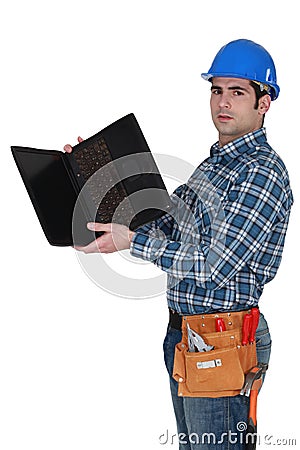 Tradesman looking at laptop Stock Photo