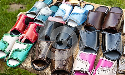 Trading in the market of shoes with flip flops made of genuine leather. Multicolour woven leather sandals, comfortable Stock Photo