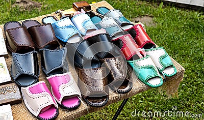 Trading in the market of shoes with flip flops made of genuine leather. Multicolour woven leather sandals, comfortable Stock Photo