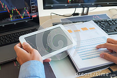 Trading on the table is working on a computer screen full of charts and data analysis and stock trading through online brokers Stock Photo