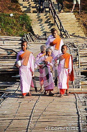 Tradition of almsgiving Burmese nuns women group procession walk on bridge for thai people respect praying put food offerings in Editorial Stock Photo