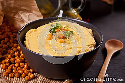 Traditional appetizer hummus with chickpea in a black bowl Stock Photo