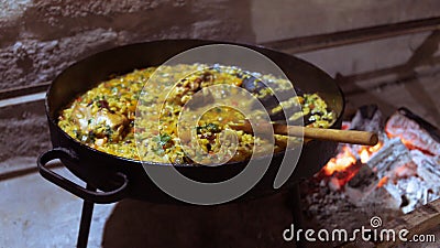 Traditional Argentinean food with chicken and rice in copper pan on the fire Stock Photo