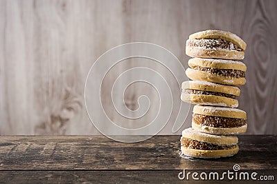 Traditional Argentinian alfajores with dulce de leche and sugar on wooden table Stock Photo