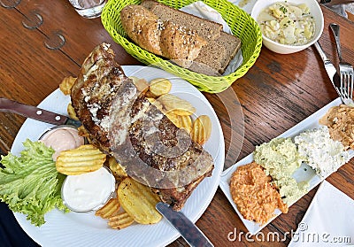 traditional Austrian dish of pork ribs with potatoes with an assortment of cheese spreads Stock Photo