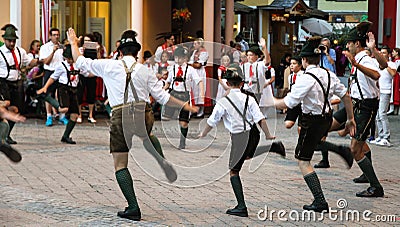 Traditional Austrian folkloric dancing performing on streets with traditional clothes garments lederhosen and dirndls. Editorial Stock Photo