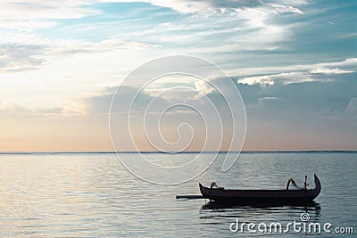 Traditional Bali Fishing Boat Without Passenger Floating On A Very Calm and Peaceful Ocean Stock Photo