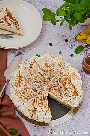 Traditional Banoffee pie with fresh bananas, whipped cream, chocolate, coffee and toffee. No baking dessert. Vertical orientation Stock Photo