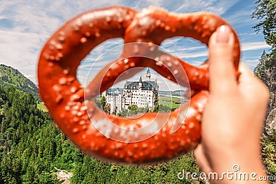 Bavarian brezel or pretzel on the background of the famous German castle Neuschwanstein. Travel and tourism concept Stock Photo