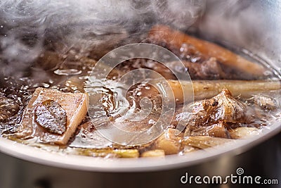 Traditional beef broth with vegetable, bones and ingredients in pot, cooking recipe Stock Photo