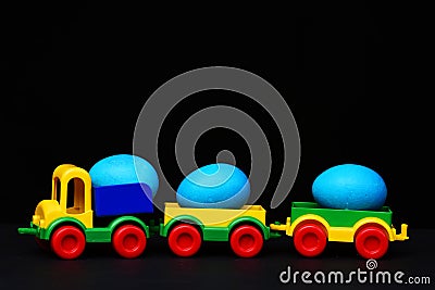 Traditional blue eggs in plastic colorful car toy or locomotive Stock Photo