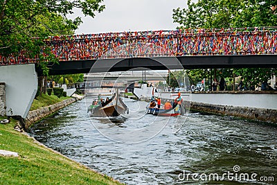 Traditional boat, Moliceiro, transporting tourists passing under bridge covered in confetti on canal at Aveiro, Portugal Editorial Stock Photo