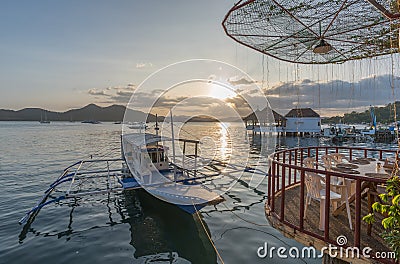 Traditional boat at terrace cafe at Coron Town at sunset view Stock Photo