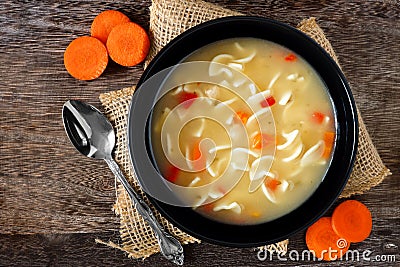 Traditional chicken noodle soup, overhead scene on rustic wood Stock Photo